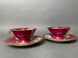 a pair of pink and gold cups and saucers