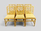 quatre chaises en bambou avec des coussins jaunes sur fond gris