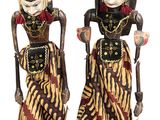 deux figurines représentant deux femmes vêtues de costumes traditionnels et tenant des cannes