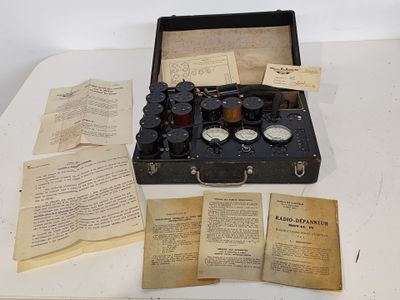 une mallette noire sur laquelle sont posés un tas de vieux papiers