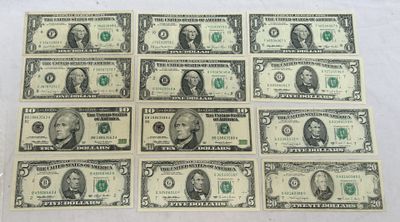 des billets de six dollars sont alignés les uns à côté des autres sur une surface blanche