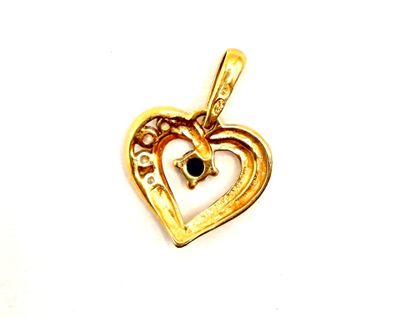 a close up of a gold heart pendant with a cross on it