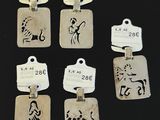 six silver charms with zodiac signs on them on a black surface