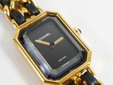 a black and gold watch with a chain around it
