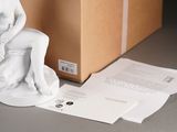 a statue of a woman sitting on a box next to a package