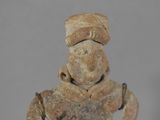 figurine of a man with a hat on his head and hands on his hips