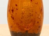a brown vase sitting on top of a wooden table
