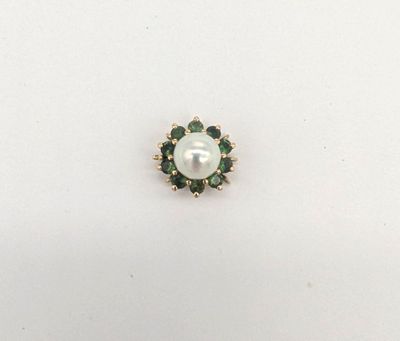 un gros plan d'une perle blanche et de pierres vertes sur un fond blanc