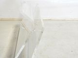 a clear piece of plastic on the floor next to a wall