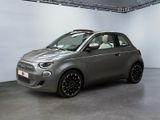 La petite voiture est garée dans une grande pièce aux murs blancs.