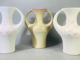 trois vases posés l'un à côté de l'autre sur une table
