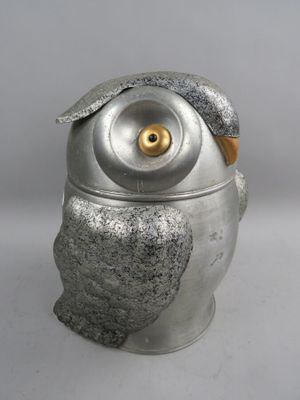 un hibou en argent perché sur un récipient en argent