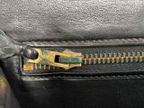 a close up of a zipper on a black purse