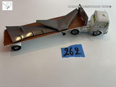 un camion miniature avec un morceau de bois à l'arrière