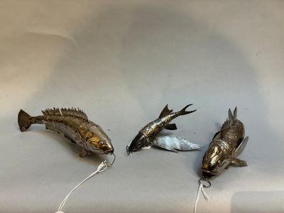 trois poissons posés sur une surface blanche