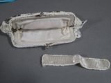 a white purse and a pair of eyeglasses on a table