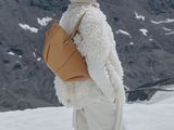 a man that is standing in the snow with a backpack