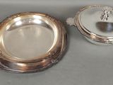 two silverplated dishes on a table with a silver lid