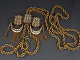 a close up of a gold chain with a pair of shoes on it