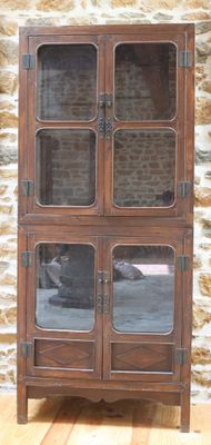 une armoire en bois avec des portes vitrées devant un mur en pierre