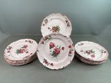 plusieurs assiettes ornées de roses roses sont empilées les unes sur les autres