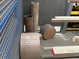 many rolls of metal sitting on the floor next to a fence