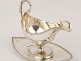 an image of a silver sauce boat on a sauce plate