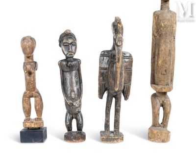 trois figurines en bois assises les unes à côté des autres sur une surface blanche