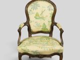 une vieille chaise dont le dossier est recouvert d'un tissu vert et blanc