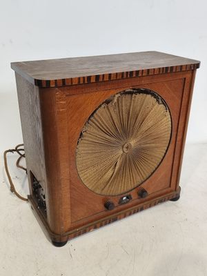 une vieille radio en bois surmontée d'un ventilateur