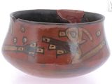 a red bowl with a dog on it on a white surface