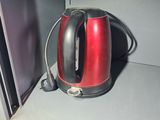 a red kettle sitting on a shelf in a microwave