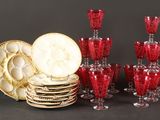 beaucoup de verres à vin rouge et d'assiettes sur la table