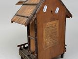 a small wooden birdhouse with a roof made of wood