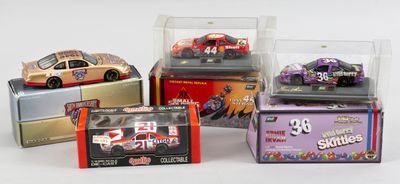 quatre voitures différentes sont exposées dans une vitrine posée sur une surface blanche