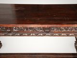 an old wooden table with carvings on the top of it