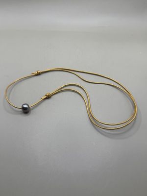 Collier lien en cuir doré orné d'une perle de Tahiti.