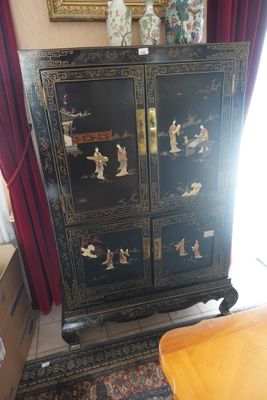 a black cabinet with oriental designs on it in a living room