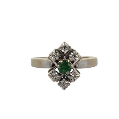 gros plan d'une bague en diamant et émeraude sur fond blanc