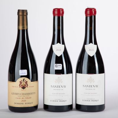 three bottles of wine are lined up on a white surface