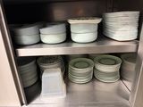 de nombreuses assiettes et bols empilés sur une étagère dans la cuisine
