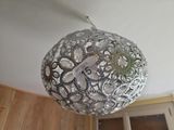 a silver ball hanging from the ceiling with a clock on it