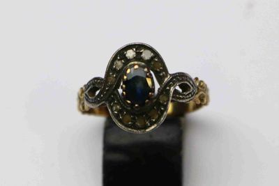 gros plan d'une bague en or avec une pierre bleue