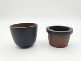 deux tasses posées côte à côte sur une surface blanche