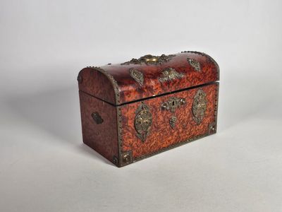 une petite boîte en bois ornée d'un motif métallique