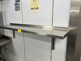 a stainless steel shelf in the middle of a kitchen