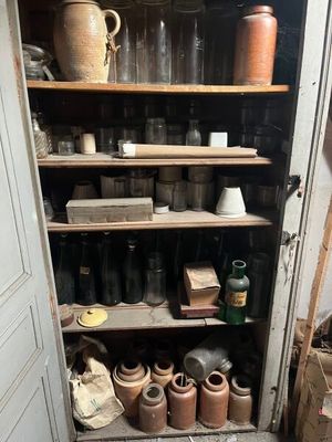 de nombreux bocaux et vases sur les étagères de la pièce