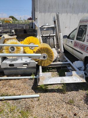 un camion garé à côté d'un autre camion sur lequel est posée une brosse