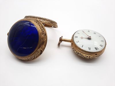 une montre-bracelet en or et une montre en lapis-lazuli posées l'une à côté de l'autre