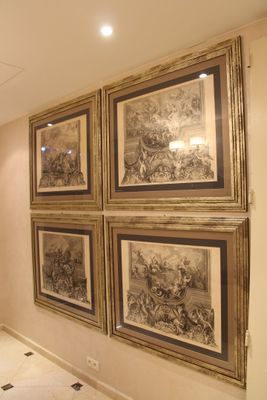 quatre tableaux encadrés accrochés au mur dans un couloir